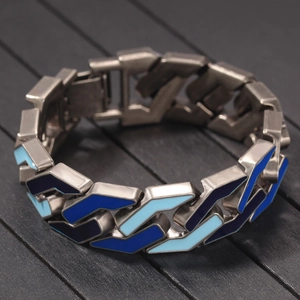 Detailed shot of hip hop geometric chain bracelet with blue enamel inlay on dark wood