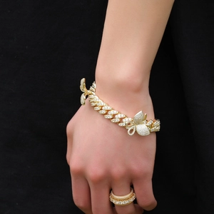 Λεπτομερής λήψη από χρυσό βραχιόλι Cuban link με λαμπερές πεταλούδες και ζιργκόν πέτρες