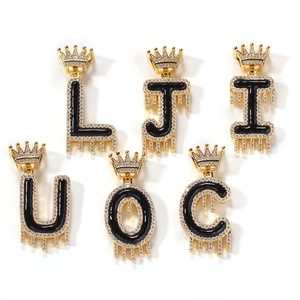 Détail de lettres hip hop avec couronne et zircons cubiques en or et noir