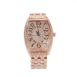 Detail view of rose gold tonneau watch with full diamond setting and large Arabic numerals