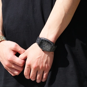 Detail of tonneau-shaped hip hop watch featuring full black rhinestones on wrist