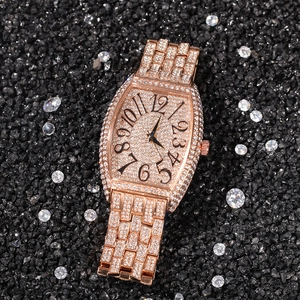 Luxurious rose gold tonneau-shaped watch with full crystal pavé and black Arabic numerals