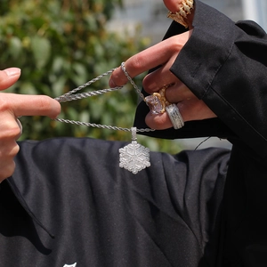 Dettaglio del ciondolo a fiocco di neve con micro-zirconi e catena a corda