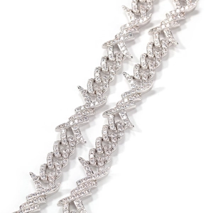Macro detail of silver hip-hop Cuban chain with thorny wire design and zircon stones