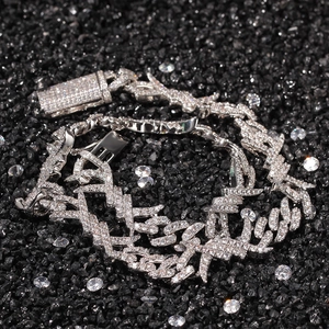 Macro detail of silver hip hop Cuban chain with barbed wire design and pave zircons
