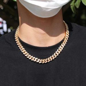 Gros plan d'une chaîne Cuban Link dorée de 12 mm sertie de zircons pour hommes