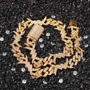 Macro shot of gold hip-hop Cuban chain with iced-out zircon thorns and pavé clasp