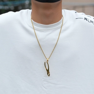 Nahaufnahme der goldenen Edelstahl-Kordelkette mit Hammer-Anhänger an einem Model
