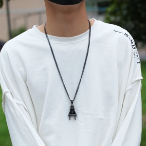 Detailweergave van een zwarte roestvrijstalen stekkerhanger aan een schakelketting