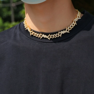 Close-up of hip hop gold Cuban link necklace with thorns and paved white zircons