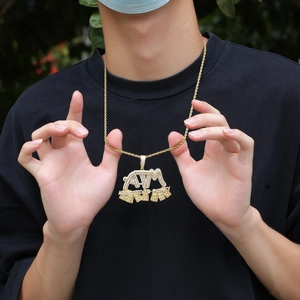 Detail of hip hop gold ATM pendant with white cubic zirconia on a rope chain