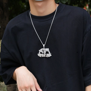 Silver-tone hip hop ATM pendant with cubic zirconia on model wearing a black t-shirt