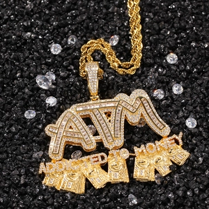 Macro shot of gold ATM letter pendant with iced-out zircons and rope chain in hip hop style