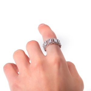 Macro detail of silver eternity ring featuring rectangular zircon stones in prong setting