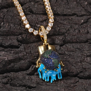 Close-up of hip hop earth pendant held by golden hands on tennis chain necklace
