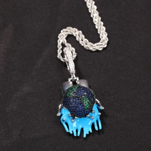 Macro detail of Earth pendant with blue and green zircons on silver rope chain