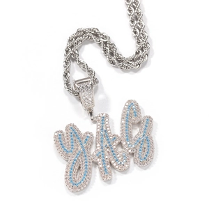 Macro detail of silver rope chain with iced-out YTG cursive letter pendant in blue stones