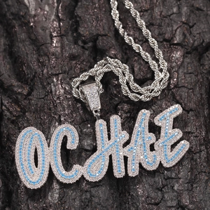 Macro shot of custom cursive OCHAE pendant with iced out blue and white zircons
