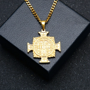 Vue détaillée du pendentif croix médaille Saint-Benoît doré sur boîte à bijoux