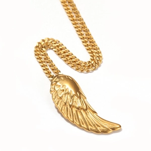 Gros plan du pendentif aile d'ange dorée avec plumes texturées sur une chaîne cubaine
