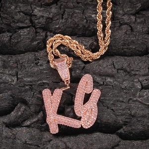 Close-up of pink zircon micro-pave KC initial pendant with rose gold rope chain