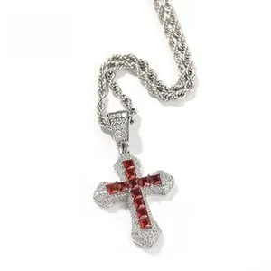 Macro detail of hip hop cross pendant with red and white zirconias on silver rope chain