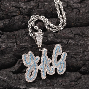 Macro shot of silver hip hop pendant with blue and white stones on a rope chain