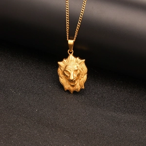 Primer plano de un colgante de cabeza de león dorado con una cadena cubana de estilo punk rock