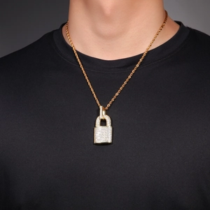 Close-up of hip hop gold padlock pendant necklace with white zircons on a male model