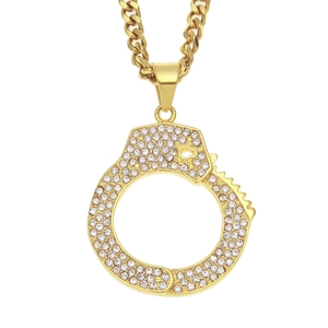 Close-up of golden chunky chain necklace with crystal-encrusted handcuff pendant