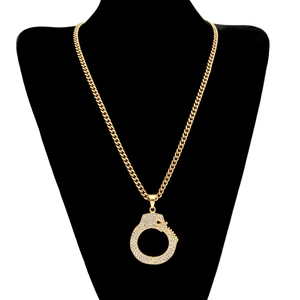 Close-up of hip-hop necklace with iced-out handcuff pendant on a black bust display