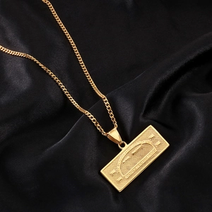 Macro shot of gold-plated dollar bill pendant necklace on elegant black silk background