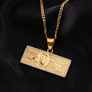 Macro view of gold 100 dollar bill pendant with pavé cubic zirconia and cuban chain