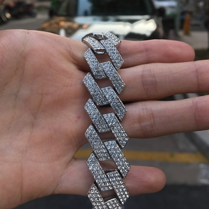 Detailed view of silver iced out Cuban chain with three rows of sparkling crystals