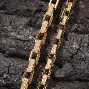 Makroaufnahme einer 8mm Gold-Hip-Hop-Kette mit Zirkonsteinen auf Kohle-Hintergrund
