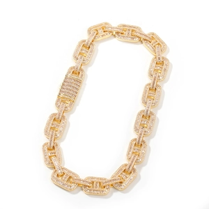 Close-up of gold hip hop Cuban chain with baguette-cut zircon stones and square clasp