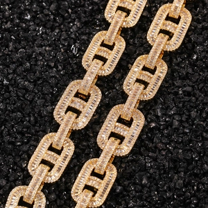Macro detail of gold plated 15mm cuban link chain with paved baguette cubic zirconia