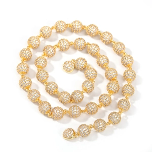Detail of golden ball chain necklace featuring iced-out white cubic zirconia stones