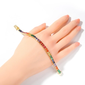 Detailed macro view of rainbow cubic zirconia stones on a gold-plated tennis bracelet