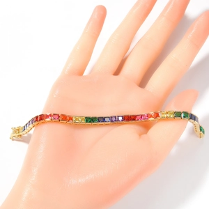 Detailed macro view of square cut rainbow zircons set in a gold plated tennis bracelet