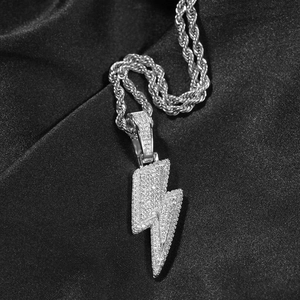 Detailed close-up of a silver lightning bolt pendant with pavé cubic zirconia on black silk