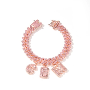 Dettaglio catena cubana oro rosa ghiacciata con zirconi rosa e ciondoli con lettere GEM