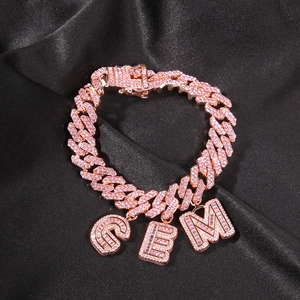 Dettaglio del bracciale cubano in oro rosa con ciondoli GEM in zircone rosa su seta nera