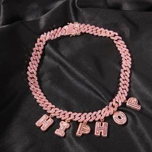 Vista macro dei ciondoli HIPHOP in cristallo rosa sulla collana a maglia cubana oro rosa