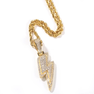 Detailed macro view of iced out lightning bolt pendant with golden rope chain
