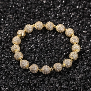 Detail shot of hip hop gold beaded bracelet with pave-set zircon stones on black stone