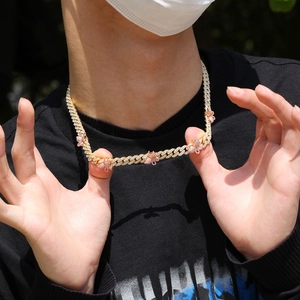 Detail einer 9mm Iced Out Kuba-Kette mit rosa Schmetterlingsanhängern im Hip-Hop-Stil