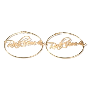Detail view of large gold-tone personalized hoop earrings with cursive script name design