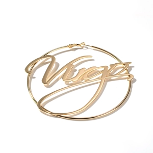 Macro view of gold hoop earrings featuring Virgo constellation script in high-polish metal