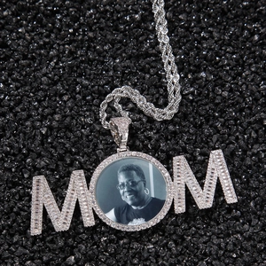 Détail du collier MOM argenté avec cristaux et portrait sur fond de pierres noires